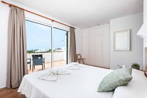 a bedroom with a white bed and a large window at Bini Rosa in Binibeca +32 photos