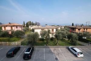 ein Parkplatz mit drei Autos, die darin geparkt sind in der Unterkunft Casa Marisa sul Garda in Toscolano-Maderno