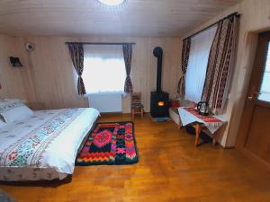 ein Schlafzimmer mit einem Bett und einem Herd in einem Zimmer in der Unterkunft Casa de la ferma Mariuca in Berbeşti