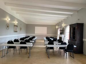 a room with rows of tables and black chairs at Beaulerland Manor House in Ermelo