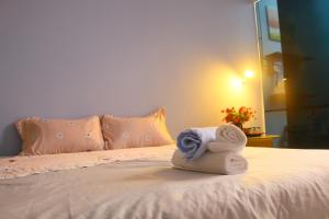 ein Bett mit zwei gewalzten Handtüchern darüber in der Unterkunft Keydeo Homestay - Phan thiet in Phan Thiet
