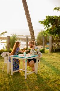 due persone sedute a un tavolo nell'erba di Shangrela Beach Resort by ARK a Ambalangoda