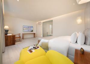 a hotel room with two beds and a yellow couch at Chengdu Chengshe Hotel - Wenjiang University Town Southwest Caida Branch in Chengdu