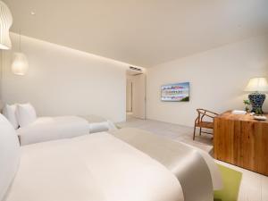 a white bedroom with a white bed and a wooden cabinet at Chengdu Chengshe Hotel - Wenjiang University Town Southwest Caida Branch in Chengdu