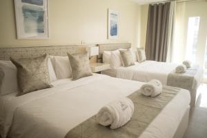 a hotel room with two beds with towels on them at Casa Marta Hotel in Iloilo City