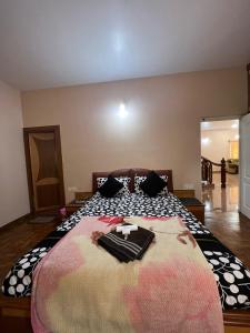 Un dormitorio con una cama grande con ropa. en Chill Inn - Families Only en Ooty