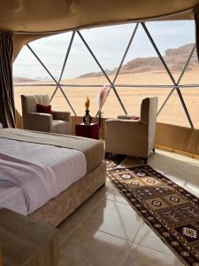 a bedroom in a tent with a bed and chairs at Queen's Magic Camp in Disah