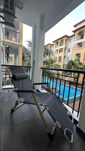 una silla en el balcón con vistas a la piscina en Desaru Homestay Southern, Tiara Desaru Seaview Residensi en Bandar Penawar