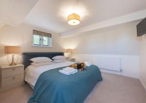 una camera da letto con un cane seduto su un letto di 1 The Homestead a Frostenden