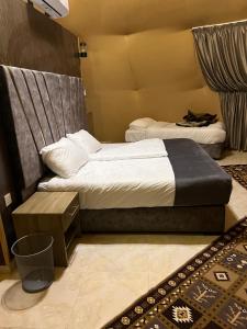 a bedroom with two beds and a rug at Queen's Magic Camp in Disah