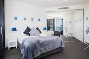 a bedroom with two beds and a large mirror at The Sandpiper - A Newy Beachfront Beauty in Newcastle