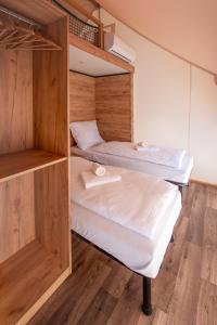 two bunk beds in a room with wooden walls at ForRest Glamping in Banská Štiavnica