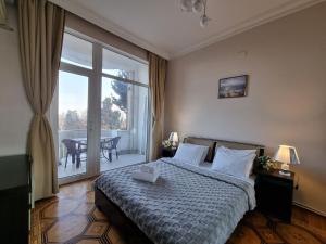 um quarto com uma cama e uma grande janela em Bulvar apart em Baku
