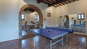 un tavolo da ping pong in una stanza con palestra di VILLA LE TORNAIE 14, Emma Villas a Monte San Savino