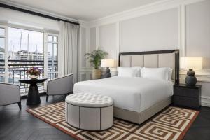 a bedroom with a white bed and a balcony at Cape Grace, A Fairmont Managed Hotel in Cape Town