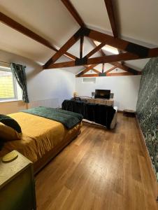 una camera con un letto in una stanza con pavimenti in legno di Aplanty House: A Hidden Gem in The Heart of The Fens a Wisbech