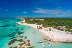 eine Luftansicht auf einen Strand mit Booten im Wasser in der Unterkunft The Westin Puntacana Resort in Punta Cana