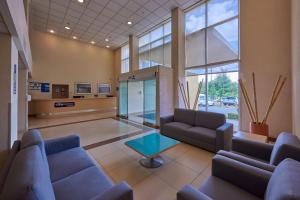 a lobby with couches and a table in a building at City Express by Marriott Puebla FINSA in Puebla