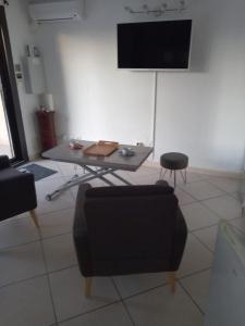 a living room with a table and a tv at Cap d'Agde Naturiste Villa Port Vénus in Cap d'Agde