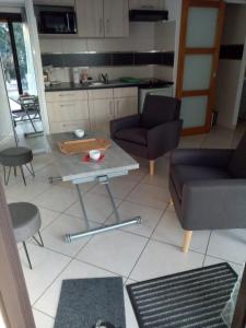 a living room with a table and chairs and a kitchen at Cap d'Agde Naturiste Villa Port Vénus in Cap d'Agde