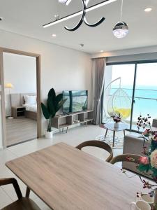 a living room with a dining table and a living room at The Sóng Apartment Vũng Tàu - Tabo Homestay in Vung Tau