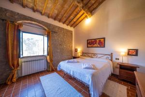sypialnia z dużym łóżkiem i oknem w obiekcie Agriturismo il Palagetto w mieście Pomarance