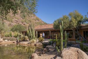 The Canyon Suites at The Phoenician, a Luxury Collection Resort, Scottsdale في سكوتسديل: الناس تقف أمام مبنى به بركة