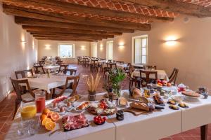 una mesa larga con comida en un restaurante en Agrisuite Le Querce del Vareglio, en Canale