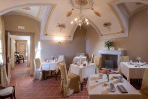 a restaurant with tables and chairs and a fireplace at Agrisuite Le Querce del Vareglio in Canale