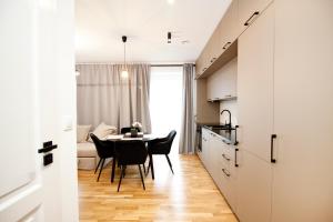 uma cozinha e sala de jantar com mesa e cadeiras em Apartamenty LAGOM em Siedlce