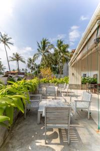 a patio with benches and palm trees at Shangrela Beach Resort by ARK in Ambalangoda