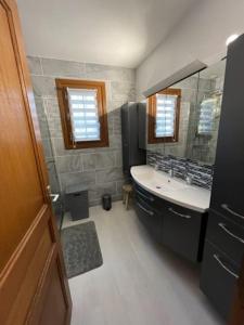 uma casa de banho com um lavatório e um espelho em LA BRUVÉCA Octeville s/Mer em Octeville-sur-Mer