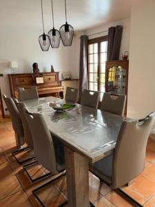 uma sala de jantar com mesa e cadeiras em LA BRUVÉCA Octeville s/Mer em Octeville-sur-Mer