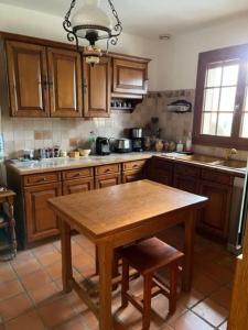 cocina con armarios de madera y mesa de madera en LA BRUVÉCA Octeville s/Mer, en Octeville-sur-Mer