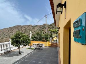 einen Balkon eines Hauses mit einem Tisch und einem Baum in der Unterkunft Casa Azul in Vallehermoso