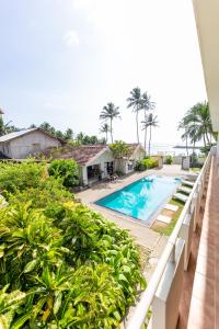 een balkon met uitzicht op het zwembad van een resort bij Shangrela Beach Resort by ARK in Ambalangoda