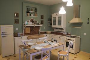 een keuken met een tafel, stoelen en een koelkast bij Suite Blue Laguna in Chioggia