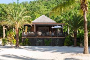 a house on the beach with palm trees at Hermitage Bay - All Inclusive in Saint Johnʼs