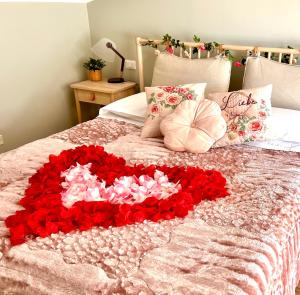 Una cama con un corazón hecho de rosas rojas en La Casa Di Campagna Sul Garda, en Puegnago sul Garda
