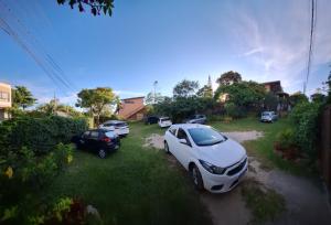 een groep auto's geparkeerd in een tuin bij Hospedaria Noite Lunar in Praia do Rosa