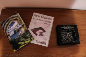 レッジョ・ディ・カラブリアにあるB&B Cuscino & Cappuccinoの- 本2冊、携帯電話1台