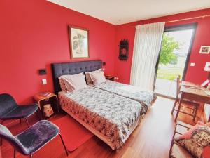 a bedroom with red walls and a bed and a window at la Palisse in Peaugres