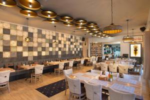 a dining room with tables and white chairs at Forum Hotel Self Check-in Stara Zagora in Stara Zagora