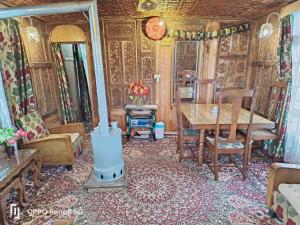 シュリーナガルにあるNormandi group of Houseboatsの暖炉とテーブルのあるリビングルーム +17枚の写真