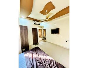 a room with a bed and a flat screen tv at Hotel Dreamland, Somnath in Somnath