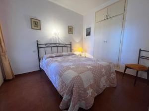 1 dormitorio con cama, lámpara y silla en Basic Comfort Apartment Gran Reserva Platja 0071, en Empuriabrava