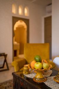 Riad la clé d'or & spa في مراكش: وعاء من الفواكه على طاولة في غرفة المعيشة