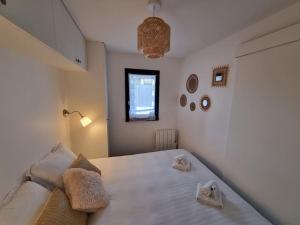 a bedroom with a large white bed with two pillows at Cosy Plage-Accès privé à la Mer in Cabourg