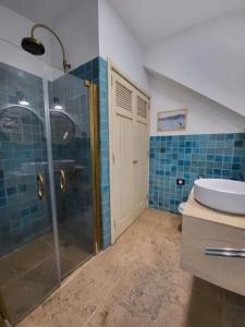y baño con ducha acristalada y lavamanos. en Villa Delicias en Melenara