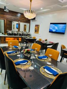 Chillers Hotel and Suites في Aiyetoto-Asogun: غرفة طعام مع طاولة وكراسي طويلة